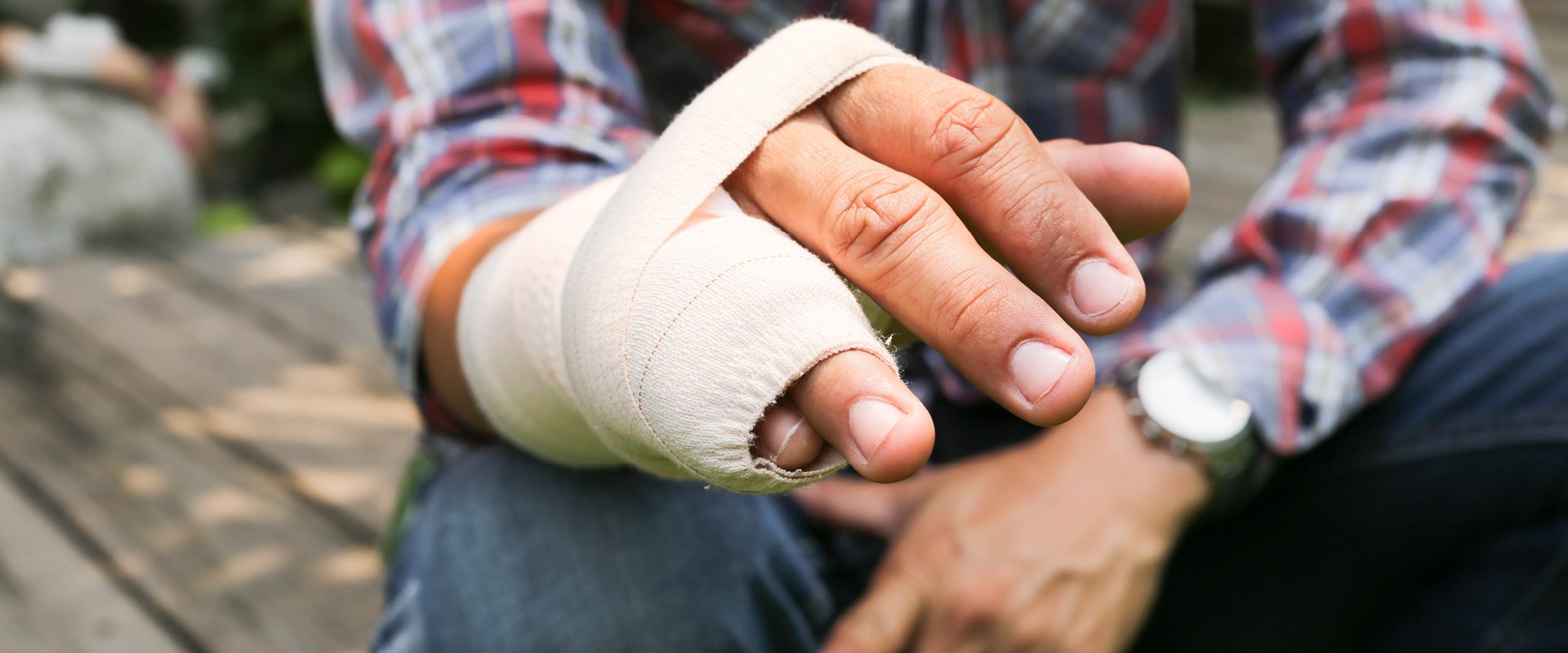 man with injured bandaged hand