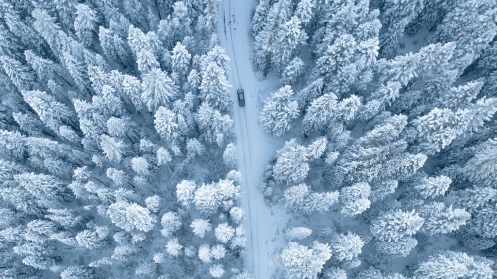 Image of a winter landscape with a car safely driving